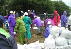 二の宮公園で土のうづくりに取り組む消防団員の写真